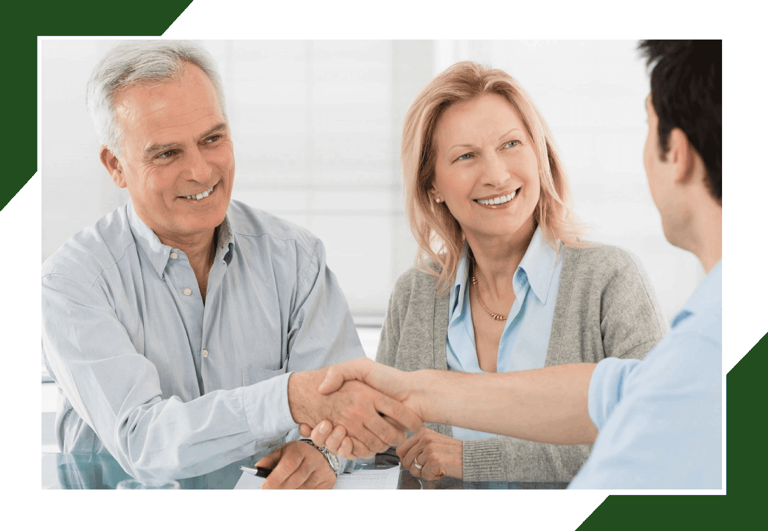 A group of people sitting around a table shaking hands.